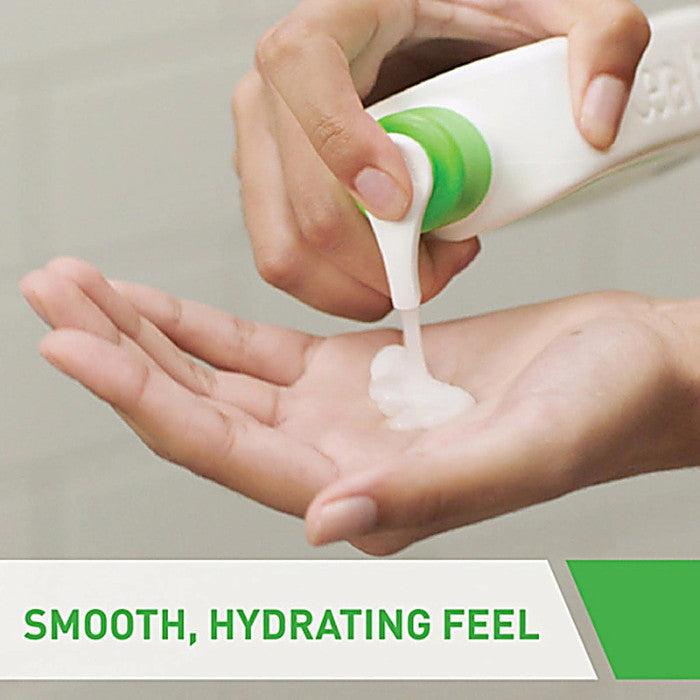 Hand applying a smooth, hydrating cream from a bottle with a green cap.