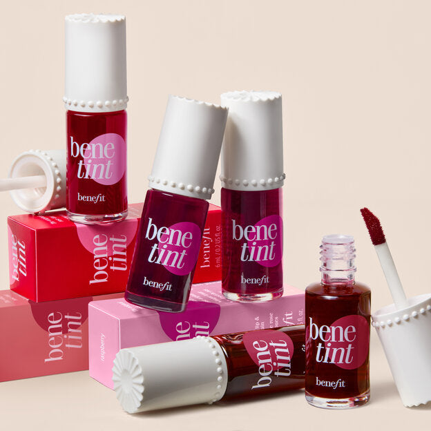 Benefit benetint lip and cheek tint bottles on a beige background