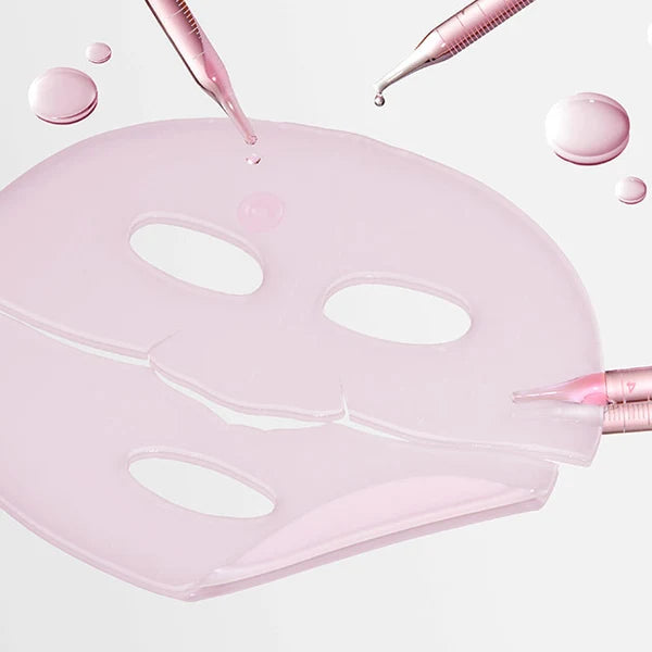 A translucent pale pink sheet mask with eye and nose cutouts, shown on a clean white background with droplets and applicator tips around it.Medicube PDRN Pink Collagen Gel Mask