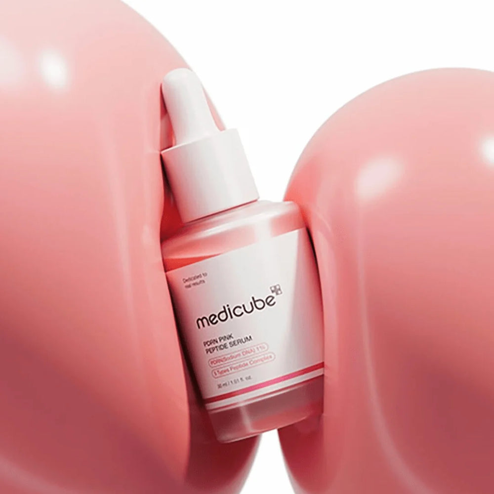 Medicube serum bottle on a pink background