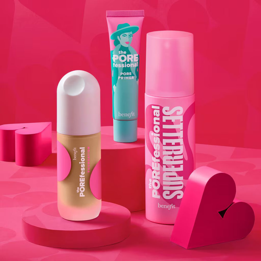 Benefit cosmetics set featuring The Porefessional Pore Primer in teal and beige, and The Porefessional Super Retinol in bright pink, styled with pink heart-shaped props on a pink background.