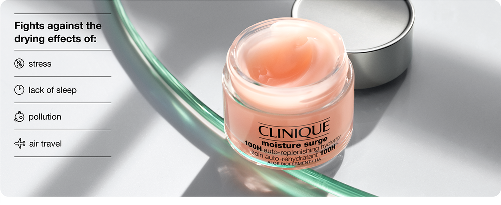 Clinique Moisture Surge 100H hydro-replenishing cream jar with its silver lid beside a curved green glass tube on a gray background, with text listing stress, lack of sleep, pollution, and air travel.