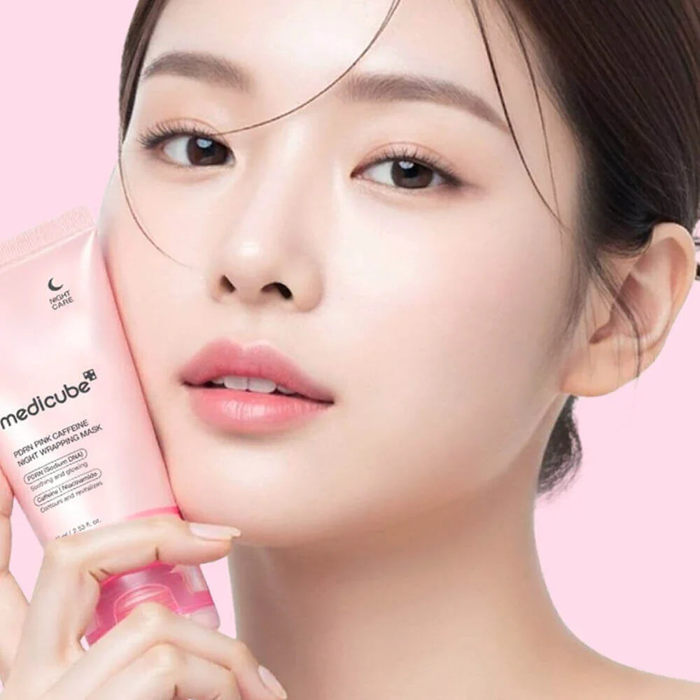 Woman holding a pink skincare product with a pink background Medicube PDRN Pink Caffeine Night Wrapping Mask 75ml