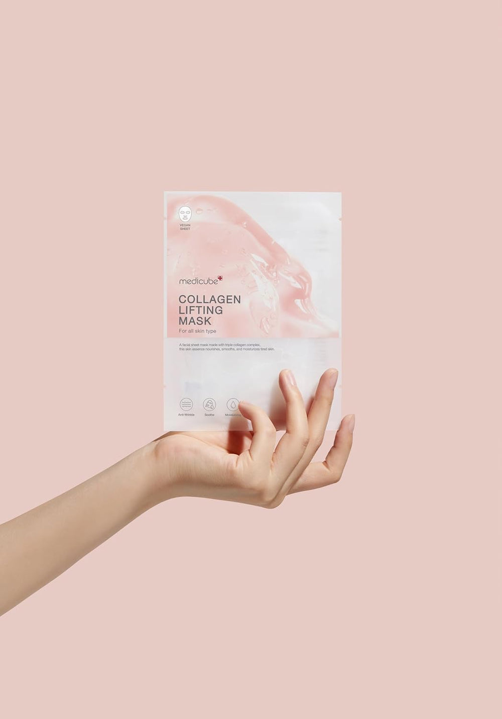 Collagen lifting mask packaging held by a hand on a pink background