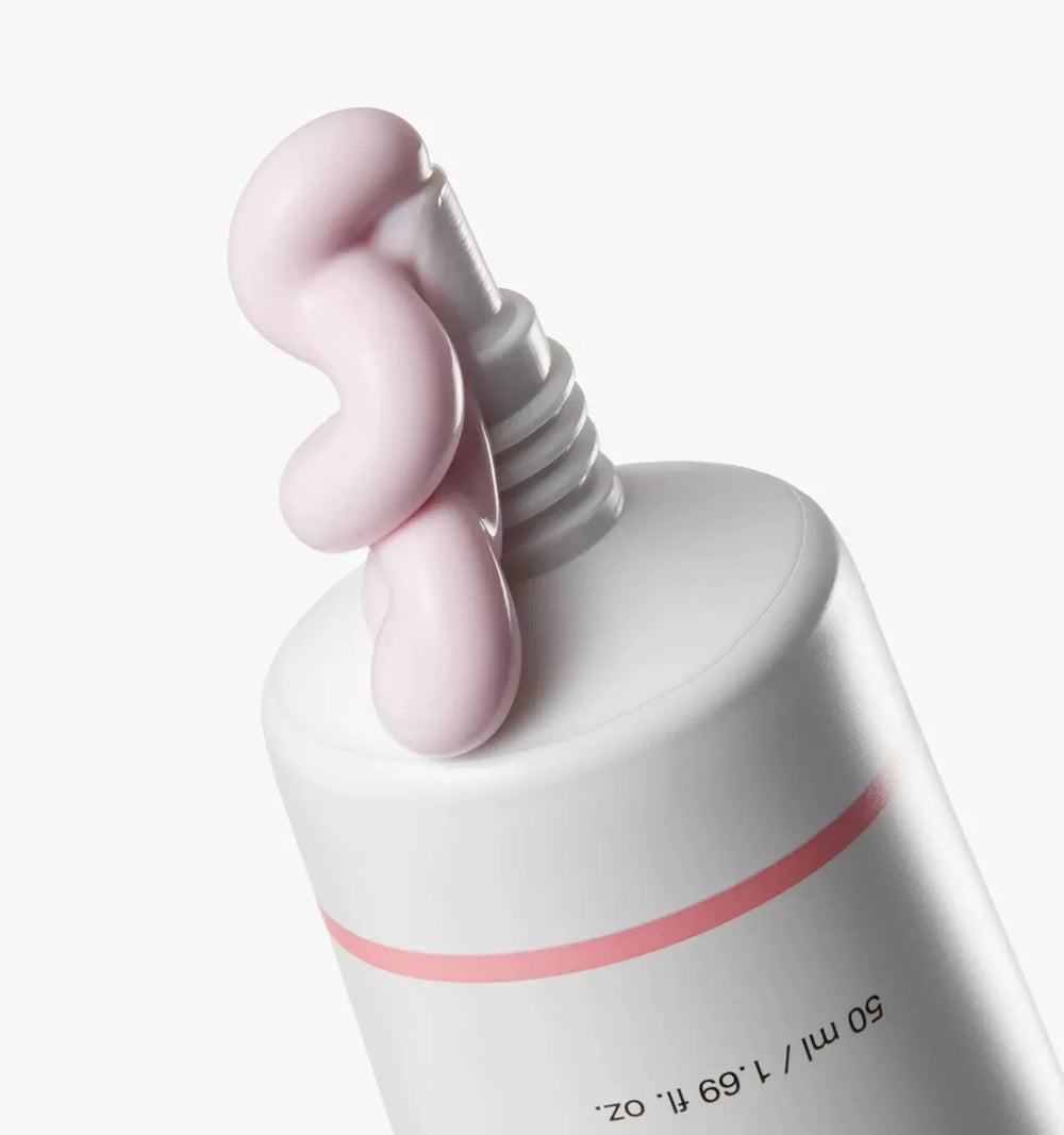 White skincare product with pink pump on a white background